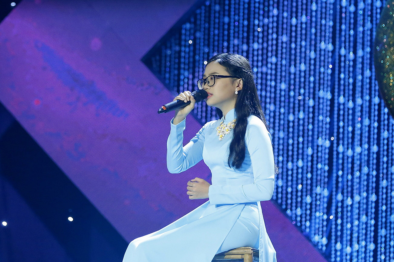 Trong tà áo dài xanh nền nã, ca sĩ nhí thể hiện ca khúc Mây chiều (sáng tác Nguyễn Nhất Huy) gửi tặng khán giả. 