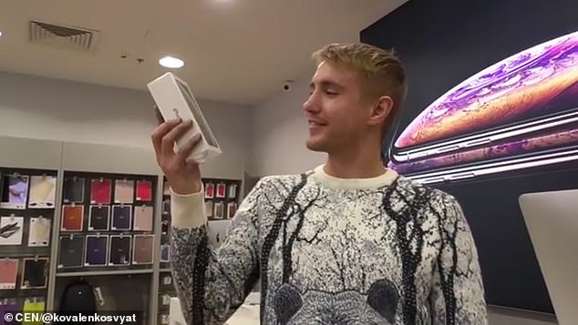 Kovalenko cầm trên tay điện thoại iPhone đời mới nhất, mua bằng hàng ngàn đồng xu.