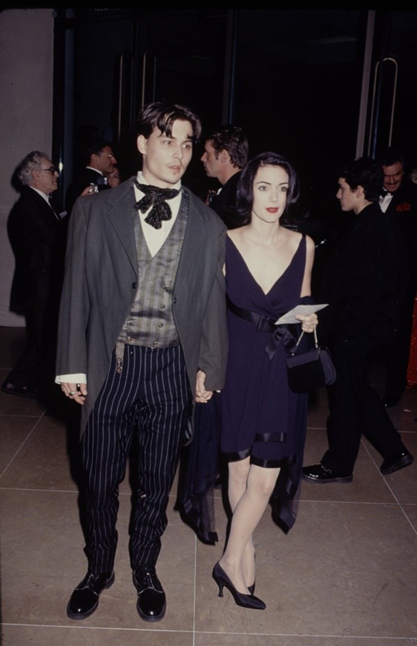 Chàng trai Johnny Depp trẻ trung năm 1990 ấy như bước thẳng từ một bức họa lên thảm đỏ, với dấu ấn không phải từ bộ lễ phục lãng tử, mà từ chiếc khăn quàng thắt thay nơ vô cùng diễm lệ.