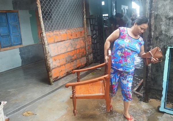 Người dân đóng cửa nhà, mang tài sản đi sơ tán do nước biển đã tràn vào sân.
