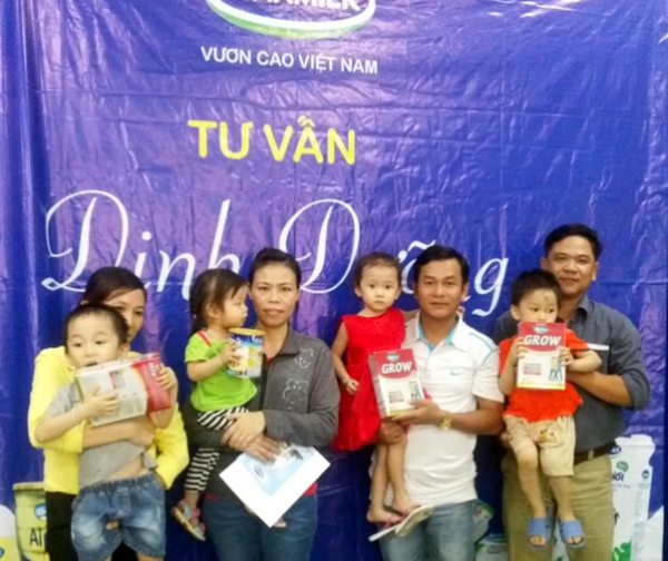 Bố mẹ cùng bé nhận qua tặng của Vinamilk.