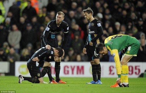 Koscielny (trái) đau đớn ôm hông trong trận đấu với Norwich