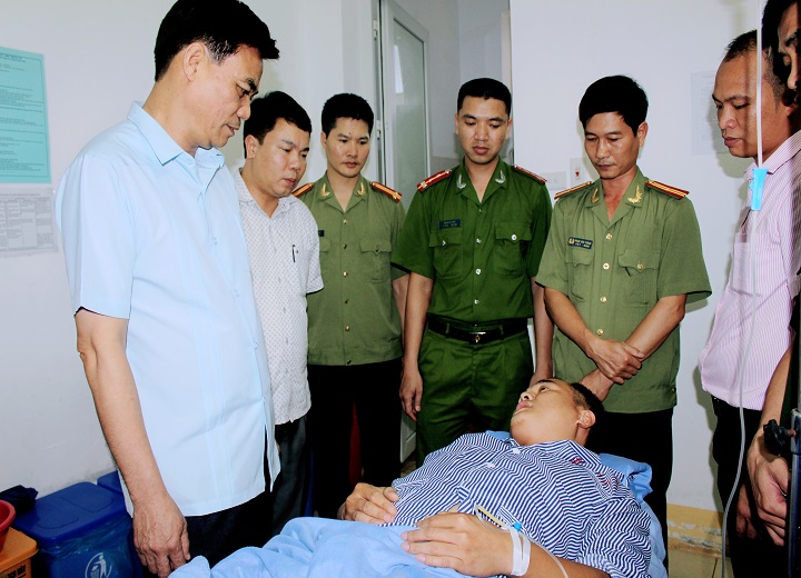 Đại tá Trần Anh Tuấn, Giám đốc Công an tỉnh Sơn La thăm hỏi, động viên đồng chí Nguyễn Minh Tú bị đối tượng dùng súng bắn trọng thương. Ảnh: Công an Sơn La