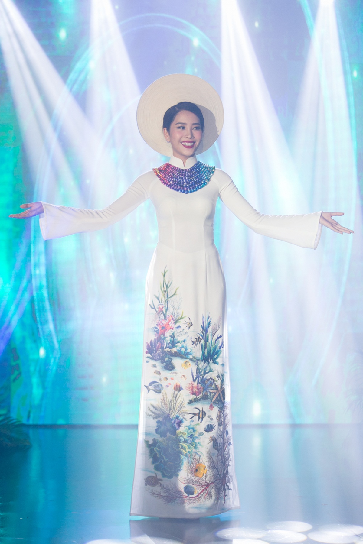Trang phục truyền thống: Áo dài dân tộc – Đại dương mênh mông (NTK Đinh Văn Thơ, thương hiệu Áo dài ABC) Với mong muốn kêu gọi mọi người chung tay góp phần bảo vệ đại dương và hệ sinh thái để trái đất mãi là hành tinh xanh, nhà thiết kế Đinh Văn Thơ thương hiệu Áo Dài ABC đã có ý tưởng khơi dậy lên những hình ảnh đẹp và sống động về đại dương trên chính tà áo dài của mình.