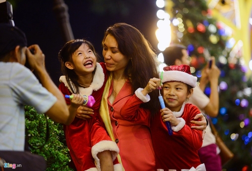 Chị Hồ Thảo (nhà ở quận Bình Thạnh) đưa hai bé Thảo Ly và Phương Trinh dạo chơi khu vực trung tâm đón Giáng sinh. Chị cho biết ngày cuối tuần ở nhà vì sợ người chen đông chật, nên chị cùng hai con dạo chơi vào tối thứ hai.  