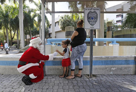 Ông già Noel tặng quà cho một bé gái bên ngoài Bệnh viện Holtz trẻ em tại Miami.