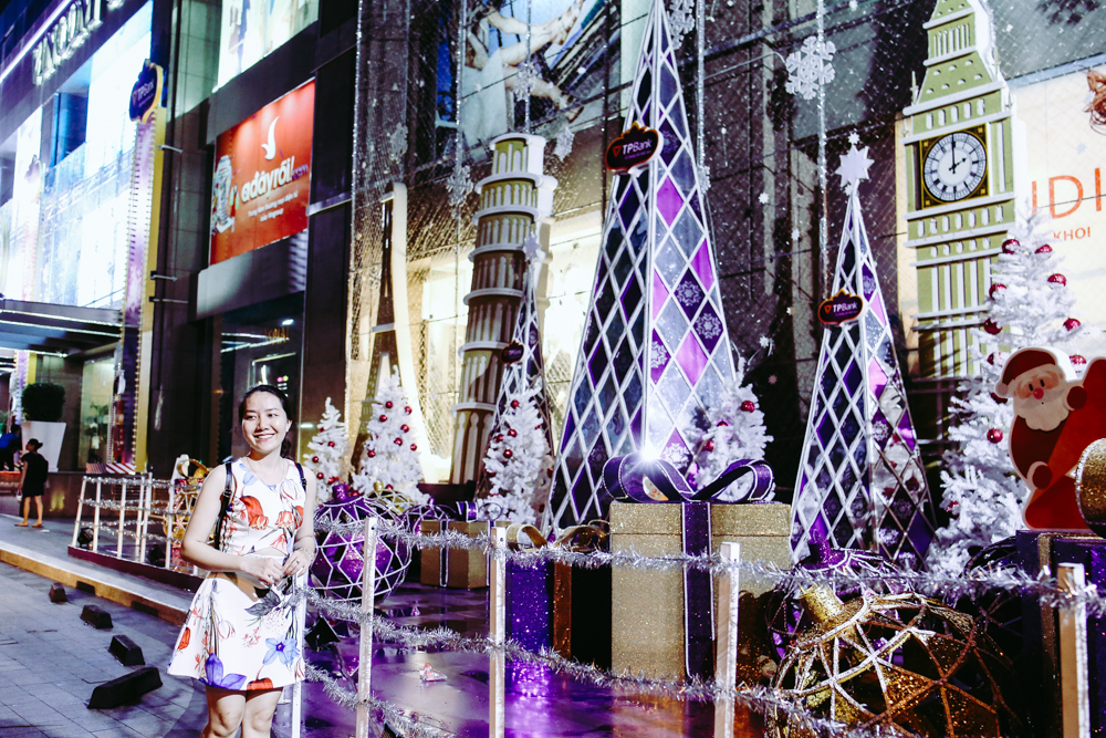 Một cô gái đang chụp nhanh tấm hình trước khi không gian trang trí Noel lên đèn