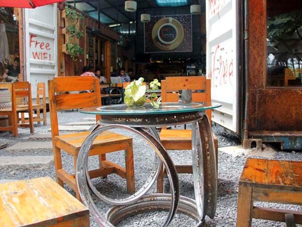 Cùng với bàn ghế gỗ, Café Contaier còn tận dụng những phụ tùng bỏ đi như vỏ xe, mâm, sên cam, vòng bi, bạc đạn... làm thành bàn uống nước và những đồ trang trí nội thất của quán nhằm gây ấn tượng với khách. Nguồn ảnh: Internet. 
