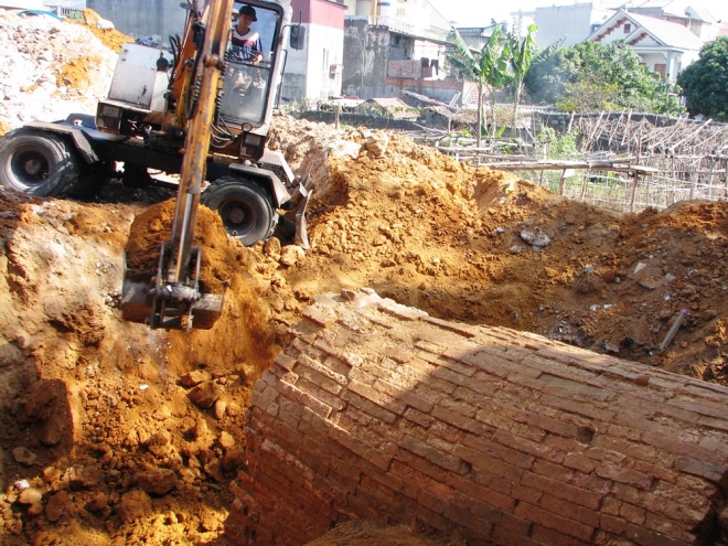 Máy xúc được điều động cào đất bề mặt và khu vực xung quanh.