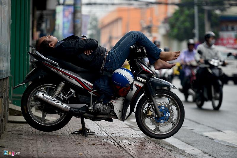 Tài xế xe ôm đậu xe trên vỉa hè đường út Tịch, quận Tân Bình mặc áo khoác ngủ ngay trên xe. Theo dự báo thời tiết, nhiệt độ tại TP.HCM trong ngày 12/12 từ 22-25 độ.