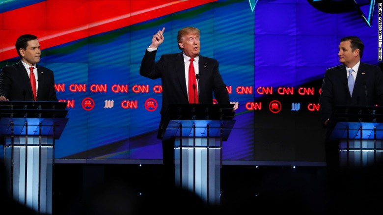 Ông Trump đứng bên cạnhThượng nghị sĩ Marco Rubio (bên trái) và Thượng nghị sĩ ed Cruz. Ông Trump phát biểu trong cuộc tranh luận của CNN ở Miami hôm 10/3. Vượt trội hơn các ứng cử viên khác, ông Trump dường như không có đối thủ ở Đảng Cộng hòa và nhanh chóng được xác định là ứng cử viên tổng thống của Đảng Cộng hòa.