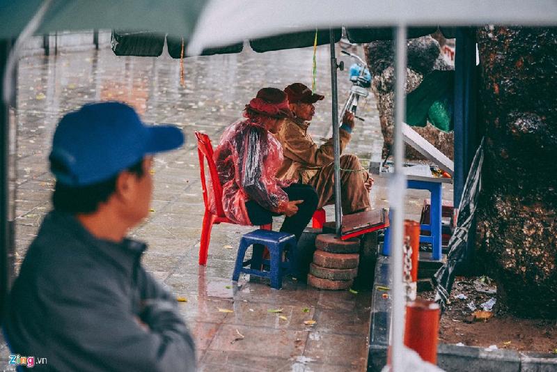 Những cảnh đời mưu sinh trong mưa lạnh hình ảnh 4 Mưa lạnh cũng làm ảnh hưởng đến những ngành nghề khác, nhiều hàng quán không có khách ra vào, từ người bán xổ số, quán nước trà ven đường hay hàng ăn ở các góc phố.