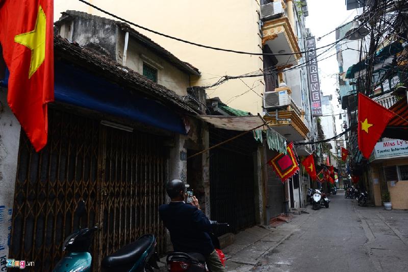 'Phó nhòm' đổ về phố cổ sáng tác đầu năm mới hình ảnh 15 Một người đàn ông ghi lại khoảnh khắc vắng lặng, rợp cờ trong phố Yên Thái bằng smartphone.