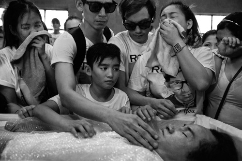 Người thân khóc than cho ông Ronnie Arroyo, 36 tuổi, một người sử dụng ma túy bị ghiết trong ngôi nhà bỏ hoang