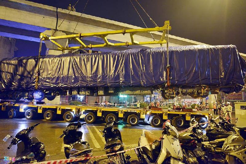 Sau thời gian chằng chéo rất lâu, đầu máy gần 35 tấn được cẩu lên trên.