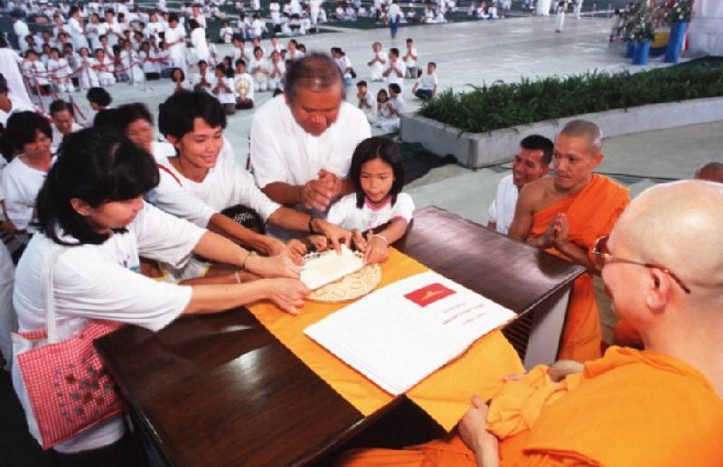 Chùa Dhammakaya được xây dựng nhờ tiền bạc và các lô đất rộng lớn được những người ủng hộ quyên tặng. Ngôi chùa này mở rộng tín đồ theo cách thức khá giống với mô hình tiếp thị đa cấp, nơi tín đồ sẽ được hưởng ưu đãi nếu lôi kéo được người mới. Trong ảnh, sư trụ trì Dhammachayo đang trao chứng nhận cho một gia đình đã quyên góp cho nhà chùa năm 1999. Ảnh: Getty.