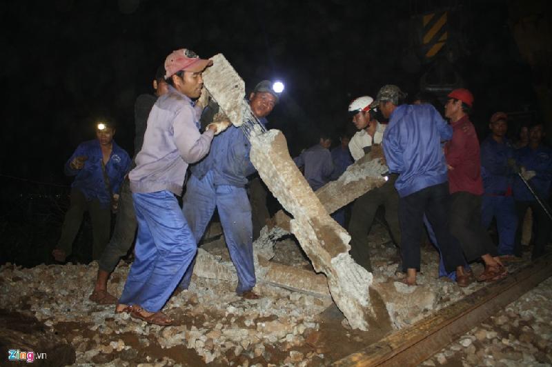 Công nhân cật lực di chuyển những cột tà vẹt bằng bê tông bị hỏng ra khỏi đường ray và tạm thời thay thế bằng tà vẹt gỗ nhằm sớm thông tuyến đường sắt Bắc - Nam.