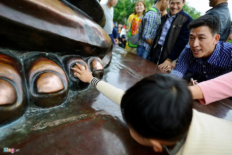 Hình ảnh xấu xí, phản cảm ngập chùa Bái Đính đầu năm mới hình ảnh 9 Anh Thành ở Vĩnh Phúc đang cố đưa con trai lên gần bàn chân tượng đồng A Di Lặc để cầu may mắn, học giỏi.
