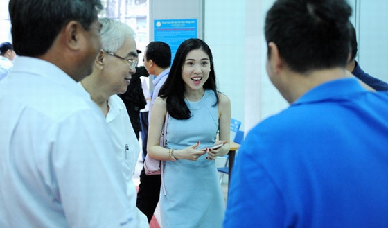 Lâm Ngân đứng cạnh bố trong lúc ông trao đổi với các đồng nghiệp.