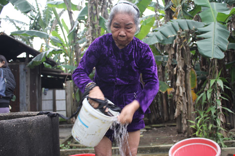Một số người còn lấy nước để rửa mặt. Ảnh N.TRI