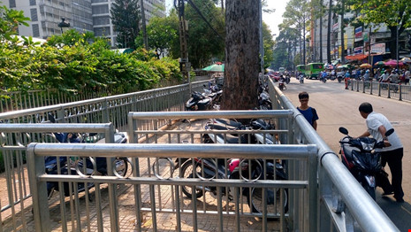 Hơn 2 tháng nay, vỉa hè trước Bệnh viện Chợ Rẫy (đường Nguyễn Chí Thanh và Thuận Kiều, quận 5) được lắp rào chắn rất kiên cố cao 1,3m để tạo lối đi cho người đi bộ. Tuy nhiên, lối ra vào khó khăn, phần vỉa hè nằm bên trong, mất vệ sinh khiến nhiều người đi bộ chọn cách đi ngay dưới lòng đường.