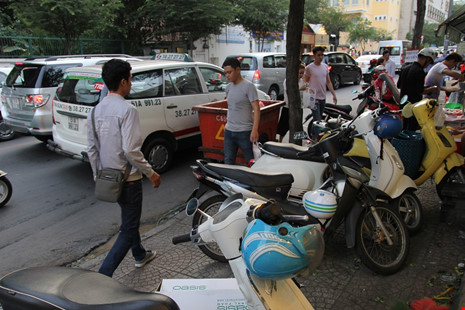 Dọc tuyến đường Hai Bà Trưng (quận 3) xe máy đậu chật kín vỉa hè người đi bộ.