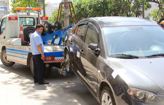 Một chiếc xe đậu trên vỉa hè bị cẩu về do tài xế vắng mặt