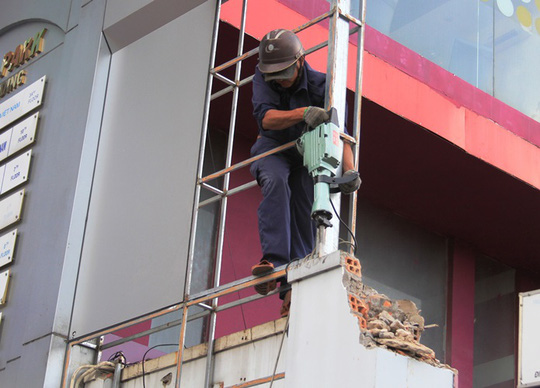 Bức tường trước số nhà 208 Nguyễn Trãi bị yêu cầu tháo dỡ từ đầu tuần nhưng chậm triển khai, lực lượng chức năng đã cưỡng chế trong buổi chiều 24-2