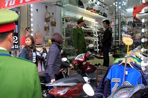Lực lượng công an lập biên bản, xử phạt và yêu cầu một chủ cửa hàng trên phố Chả Cá cho xe vào trong nhà