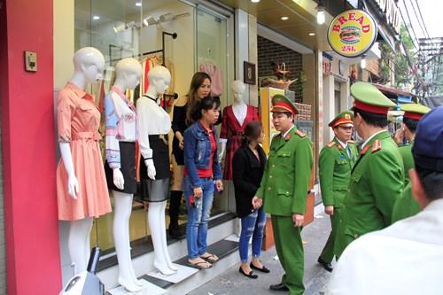 Lực lượng công an làm việc với chủ một cửa hàng thời trang