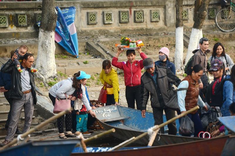 Du khách khắp nơi đổ về, người đội lễ, người bồng con nhỏ hối hả lên thuyền.