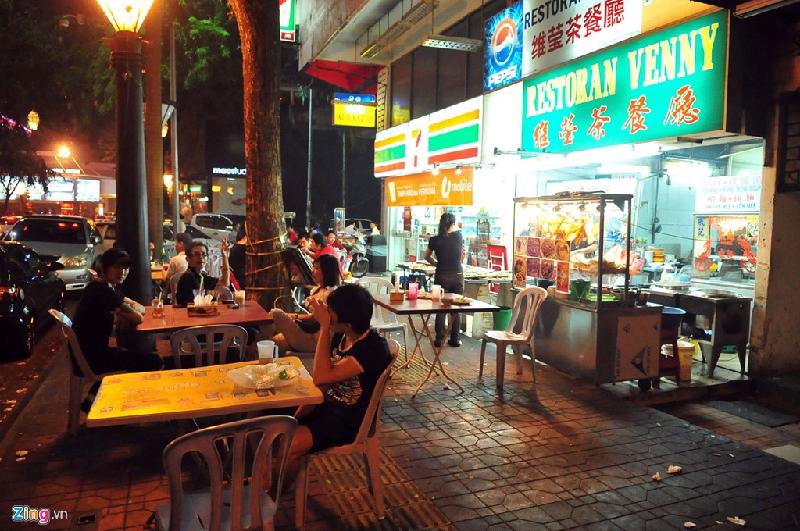 Cảnh hàng quán bày bán ghế ra vỉa hè kinh doanh không phải là lạ tại thủ đô của Malaysia cũng như Singapore láng giềng.