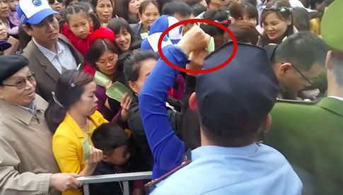 Trong một video chúng tôi ghi lại được, một phụ nữ mặc áo đen vừa giật được một tập vé của người dân ở khu vực soát vé, liền bị một người phụ nữ khác mặc áo xanh cướp lại, gây nên cảnh hỗn loạn. Hai người phụ nữ này còn chửi bới, văng tục giữa đám đông. Đáng nói, lực lượng công an, bảo vệ của lễ hội gần đó phản ứng “hời hợt” trước việc làm của người phụ nữ này, gây bất bình cho du khách tham quan.    