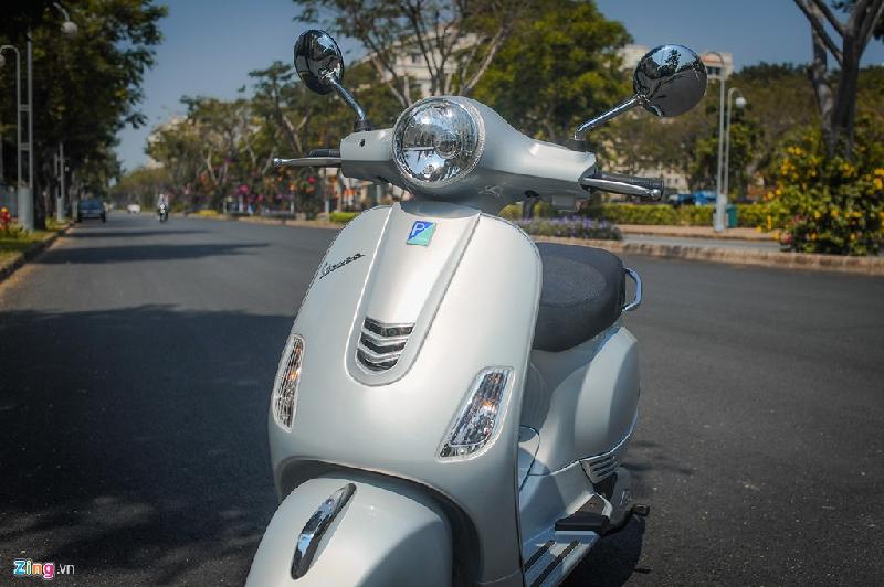 Thiết kế đầu xe của Vespa LX 2017 gần như nguyên vẹn so với trước đây. Cụm đèn pha tròn cổ điển cùng cặp gương chiếu hậu ốp chrome sáng bóng hay đèn xi-nhan là những đường nét rất quen thuộc. Trong khi đó, cà vạt ở yếm trước được thiết kế lại đôi chút. 