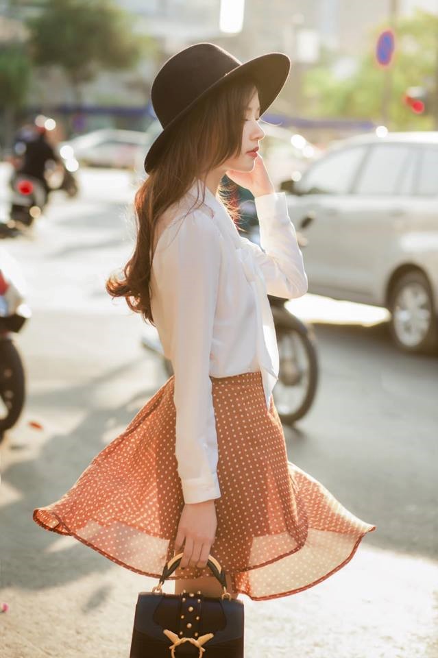 Trong khi đó, Midu chọn phong cách nhẹ nhàng khi diện áo sơ-mi trắng kết hợp chân váy voan mỏng, hoạ tiết chấm bi màu cam trẻ trung.