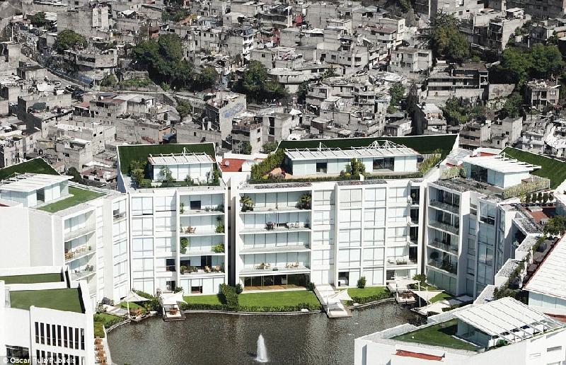 Khu căn hộ sang trọng ở Mexico City che khuất khung cảnh phía sau của các căn nhà xập xệ màu xám. Các cảnh tượng này được chụp ở những vùng đang phát triển của thế giới minh họa rõ rệt cho sự chia rẽ tồn tại giữa người giàu và người nghèo. Ảnh: Oscar Ruiz/Publicis.