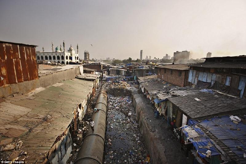 Các cư dân trong khu ổ chuột Dharavi ở Mumbai, Ấn Độ, có thể nhìn thấy các cung điện và đến thờ nguy nga ở cách họ không xa nhưng cuộc sống sang trọng nơi đó thì luôn luôn xa lạ với họ. Ảnh: 