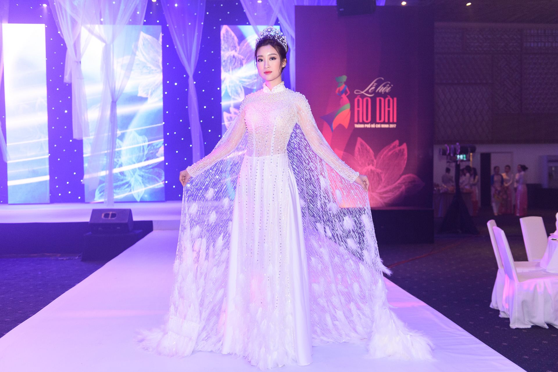 Đêm bế mạc Lễ hội Áo dài TP.HCM diễn ra tại TP.HCM ngày 17/3. Hoa hậu Đỗ Mỹ Linh làm khách mời chương trình. Người đẹp sinh năm 1996 diện áo dài trắng thiết kế cầu kỳ với sequin và lông vũ. 