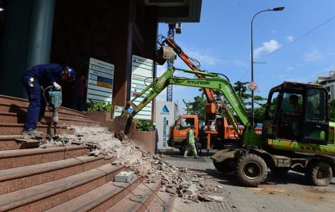 Xe múc quyết liệt xóa bỏ bậc tam cấp lấn chiếm vỉa hè phố đi bộ Nguyễn Huệ. Ảnh: Zing