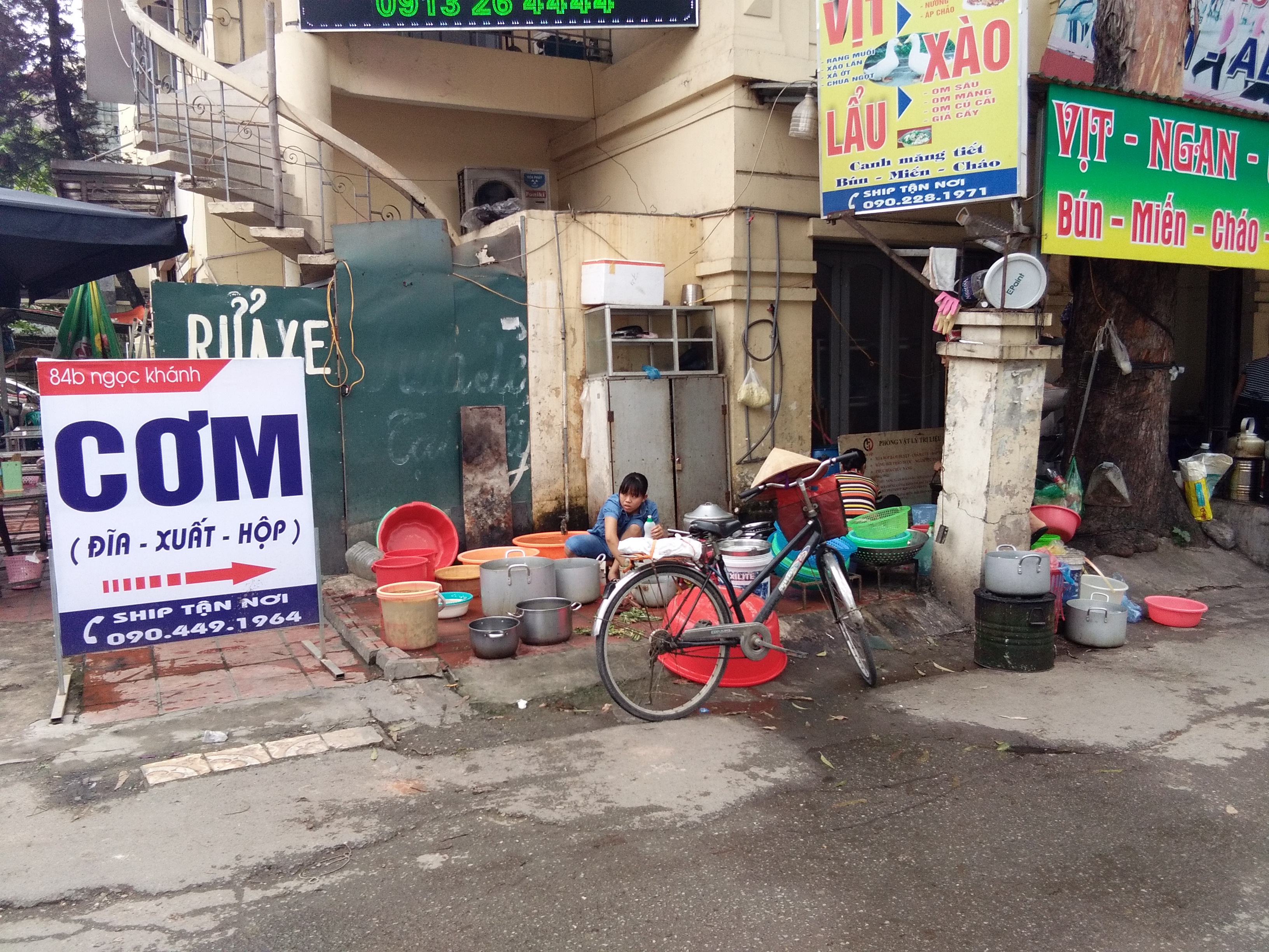 Quán cơm  chiếm hẳn chỗ vỉa hè thật to thoáng để làm nơi rửu bát.