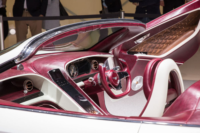 Trong khoang lái của Bentley EXP 12 Speed 6e, các chi tiết nội thất được làm từ da bọc màu đỏ vang, gỗ tự nhiên và những chi tiết ốp kim loại đánh bóng được sử dụng kết hợp một cách khéo léo. Thiết kế trong cabin của chiếc coupe chạy điện vừa ra mắt được bố trí gọn gàng và tối giản tạo cảm giác EXP 12 Speed 6e như một chiếc xe thể thao 2 cửa cơ bắp truyền thống. Mặt táp-lô và cụm hiển thị trung tâm sau vô lăng vẫn sử dụng đồng hồ kiểu kim cơ cổ điển, kết hợp với hốc gió trên xe cũng mang thiết kế tròn ốp viền độc đáo.