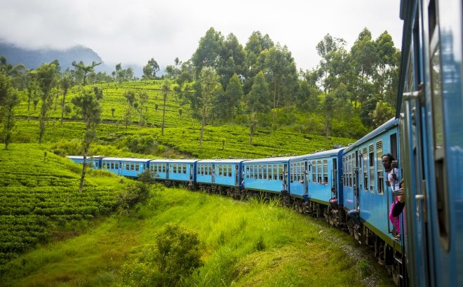 Sri Lanka: Từ Kandy tới Ella Khởi đầu từ Kandy, tàu hỏa tới Ella sẽ chạy qua những đồn điền trà và lên xuống nhiều ngọn đồi để tới một ga hẻo lánh ở giữa vùng Hill Country. Chuyến tàu này kéo dài gần 7 tiếng. Quy định trên tàu ở Sri Lanka khá thoải mái nên bạn sẽ thấy hành khách ngồi ở cửa ra vào để mở, chân vắt vẻo ra ngoài đón nắng mỗi khi tàu chạy qua đồi.