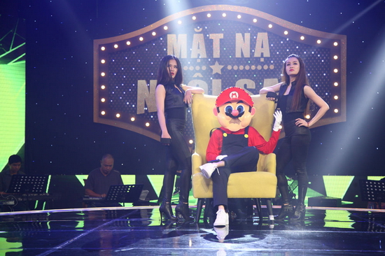 Lúc này, Đại Nghĩa khiến Nấm Lù Nhận xét về Nấm Lùn Mario, Tóc Tiên cho biết đáng lẽ anh chàng này phải hát Tình khúc vàng. Bên cạnh đó, giọng ca I’m in love còn cho biết thí sinh mặt nạ đã có gia đình và là cha của đứa trẻ khiến Hoàng Rapper dự đoán Nấm Lùn Mario có thể là anh Bo - Đan Trường. Không dừng ở đó, Tóc Tiên quyết tâm vạch mặt thí sinh mặt nạ khi cho biết anh là người miền Trung. Chi tiết hơn, Trường Giang cho biết thí sinh là người Đà Nẵng. 