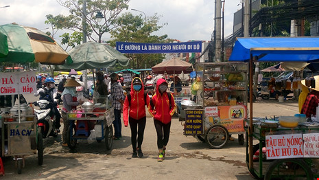 Người đi bộ chỉ còn một lối nhỏ chen giữa những xe bán hàng rong.