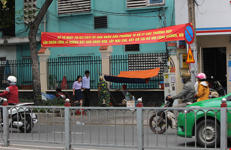 Người dân che bạt bán hàng rong trên vỉa hè đường Xô Viết Nghệ Tĩnh bất chấp băng rôn tuyên truyền treo phía trên.