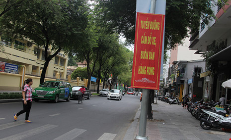 Ô tô đậu dọc đường Nguyễn Bỉnh Khiêm (quận 1) dù có nhiều băng rôn treo cấm đỗ xe.