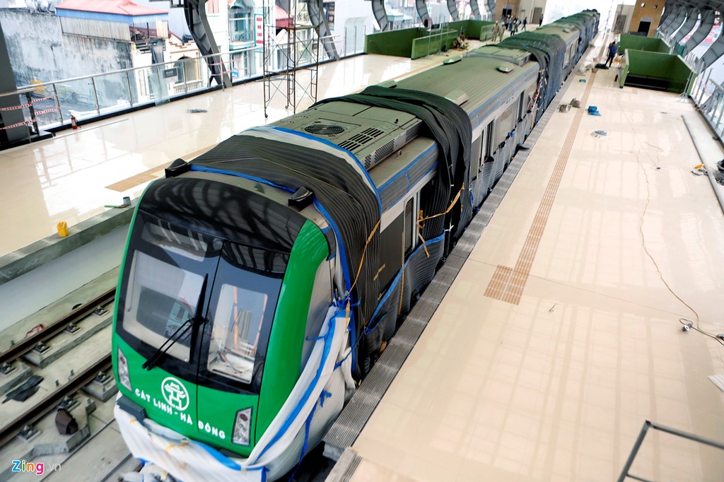 Đoàn tàu tuyến Cát Linh-Hà Đông được lắp đặt lên hệ thống ray đã 2 tháng nhưng đến nay mới lộ diện sau khi công nhân mở các tấm vải xốp phủ xung quanh.