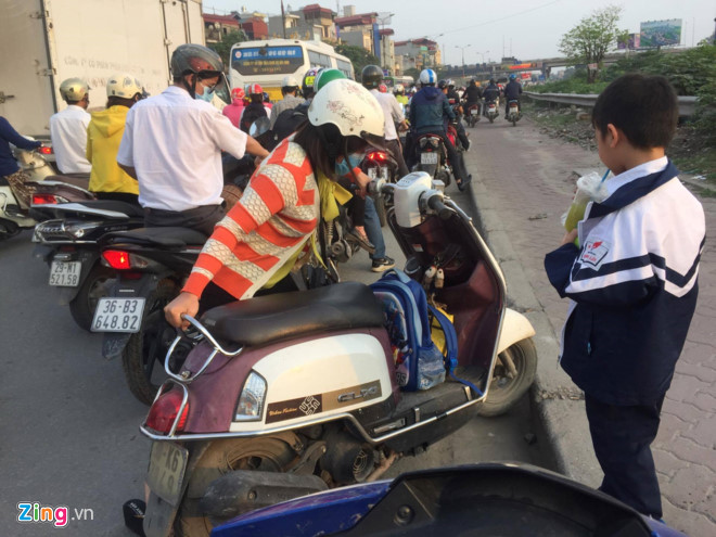 Đường Giải Phóng tắc nghẽn, một phụ huynh chở con đi học về phải dắt xe lên vỉa hè tìm cách thoát. Ảnh: Trần Anh.