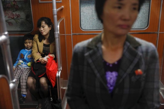 Cậu bé ngồi dựa sát mẹ trên khoang tàu.