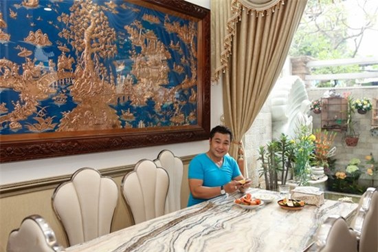 Phòng ăn đặt ngay cạnh khuôn viên của căn biệt thự. Độ sang trọng của nơi gia đình quây quần mỗi tối cũng không kém bất cứ không gian nào trong căn biệt thự. Điểm nổi bật nhất của phòng ăn là tấm phù điêu lớn ‘Vinh quy bái tổ’ đẹp tinh xảo được Lý Hùng đặt mua từ Nam Định. (Ảnh: Zing)